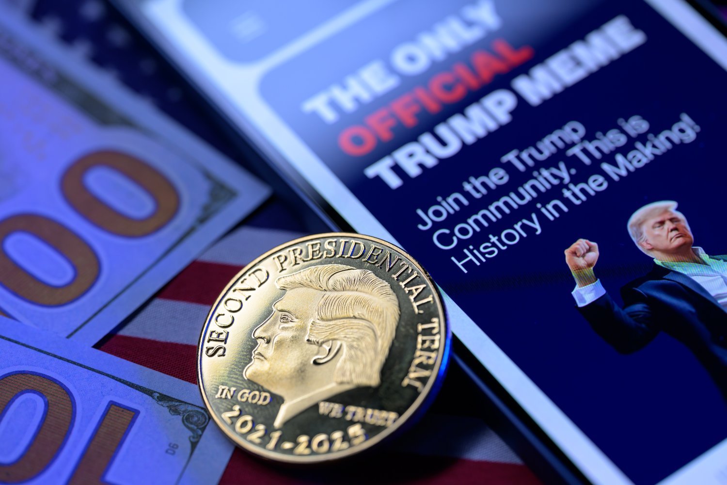 A golden Trump coin on top of dollar bills and an advertisement for the Trump meme coin.